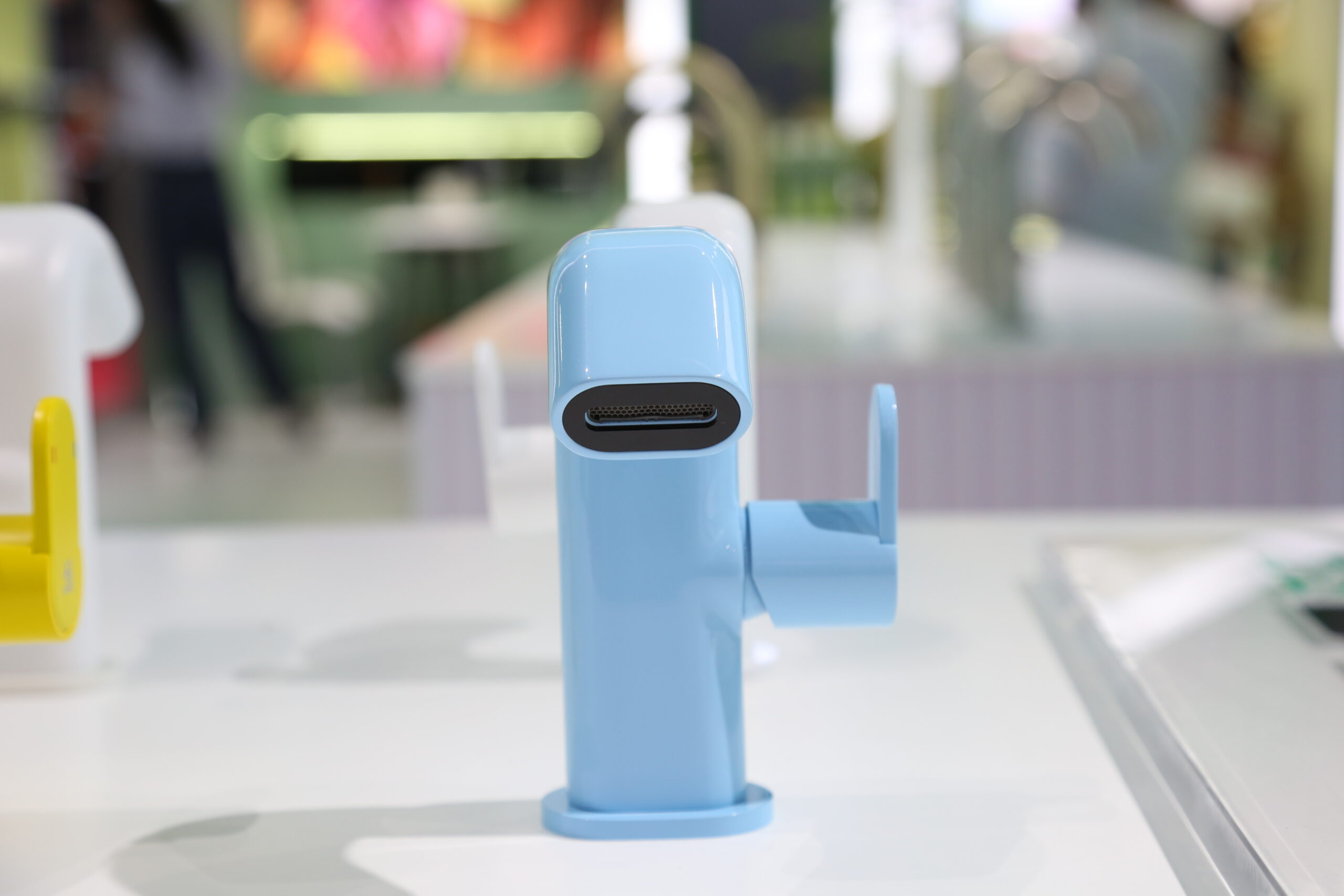 Meng Series sculptural basin mixer in Pantone 14-4123 with flip-top TPE switch - featured at KBS 2025 design exhibition on marble display