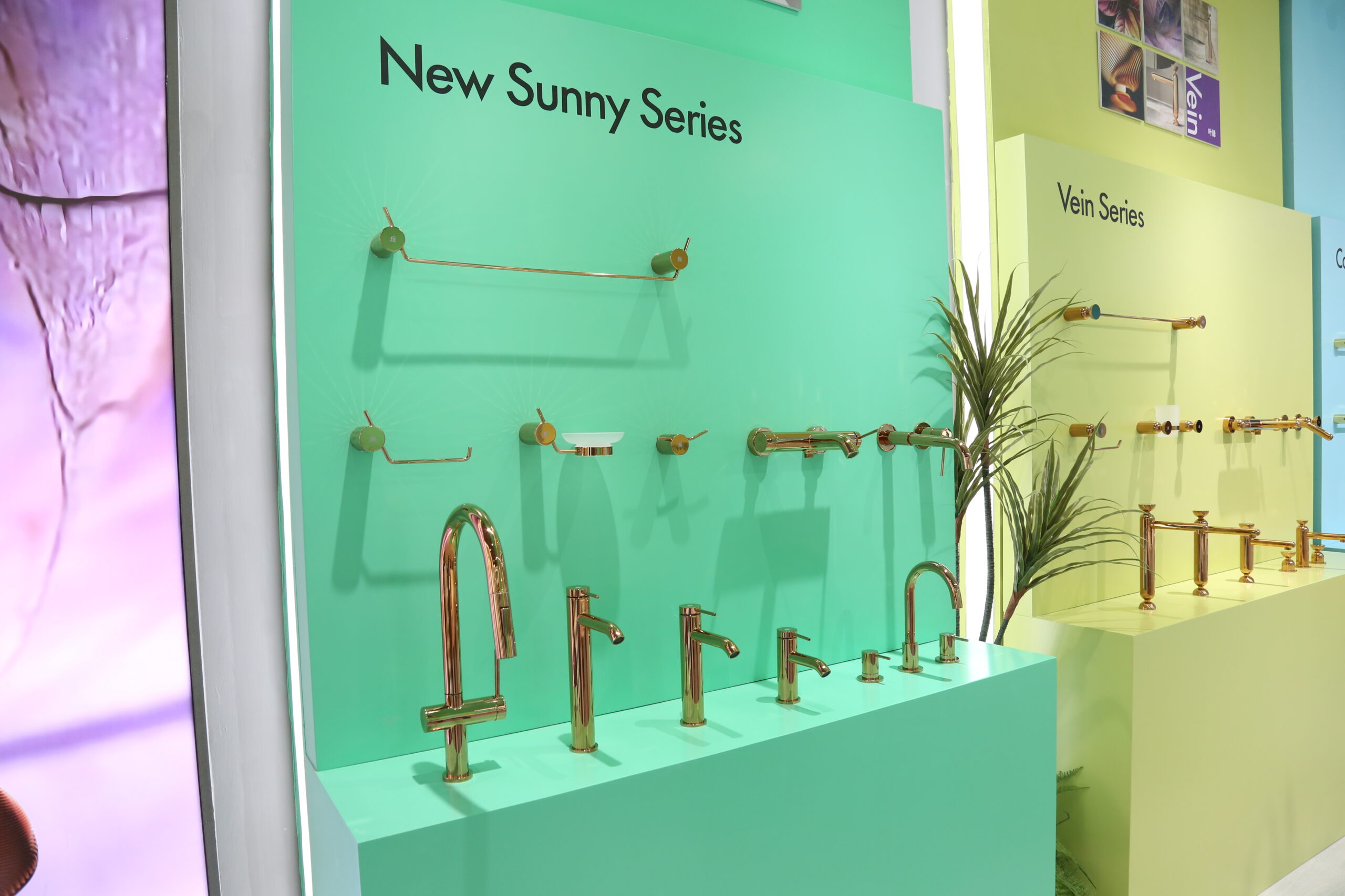 Vertical --display of rose gold bathroom faucet with curved neck and matching towel hooks on light green background.