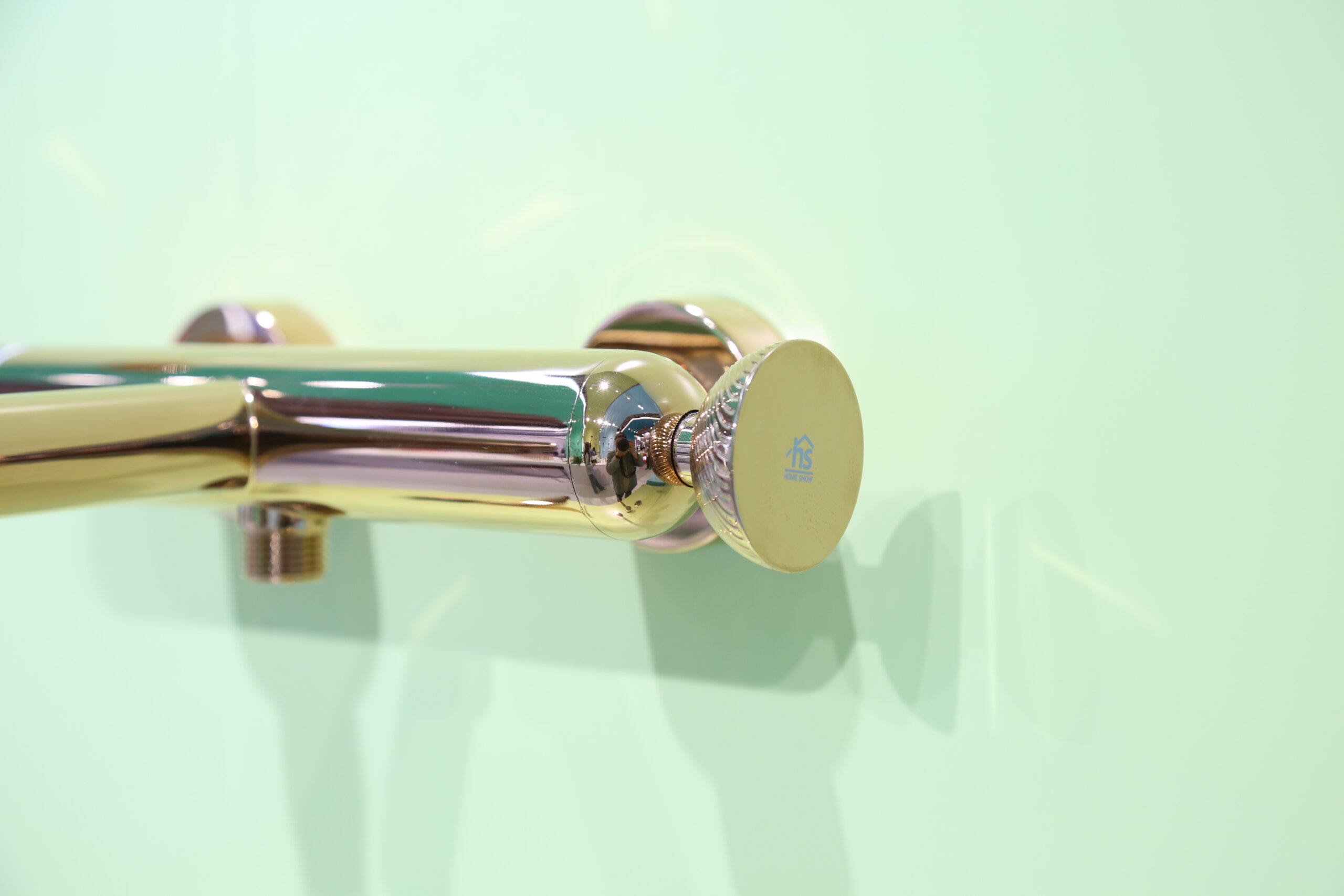 Golden Vein Series faucets aligned on light green wall - nature-inspired textures